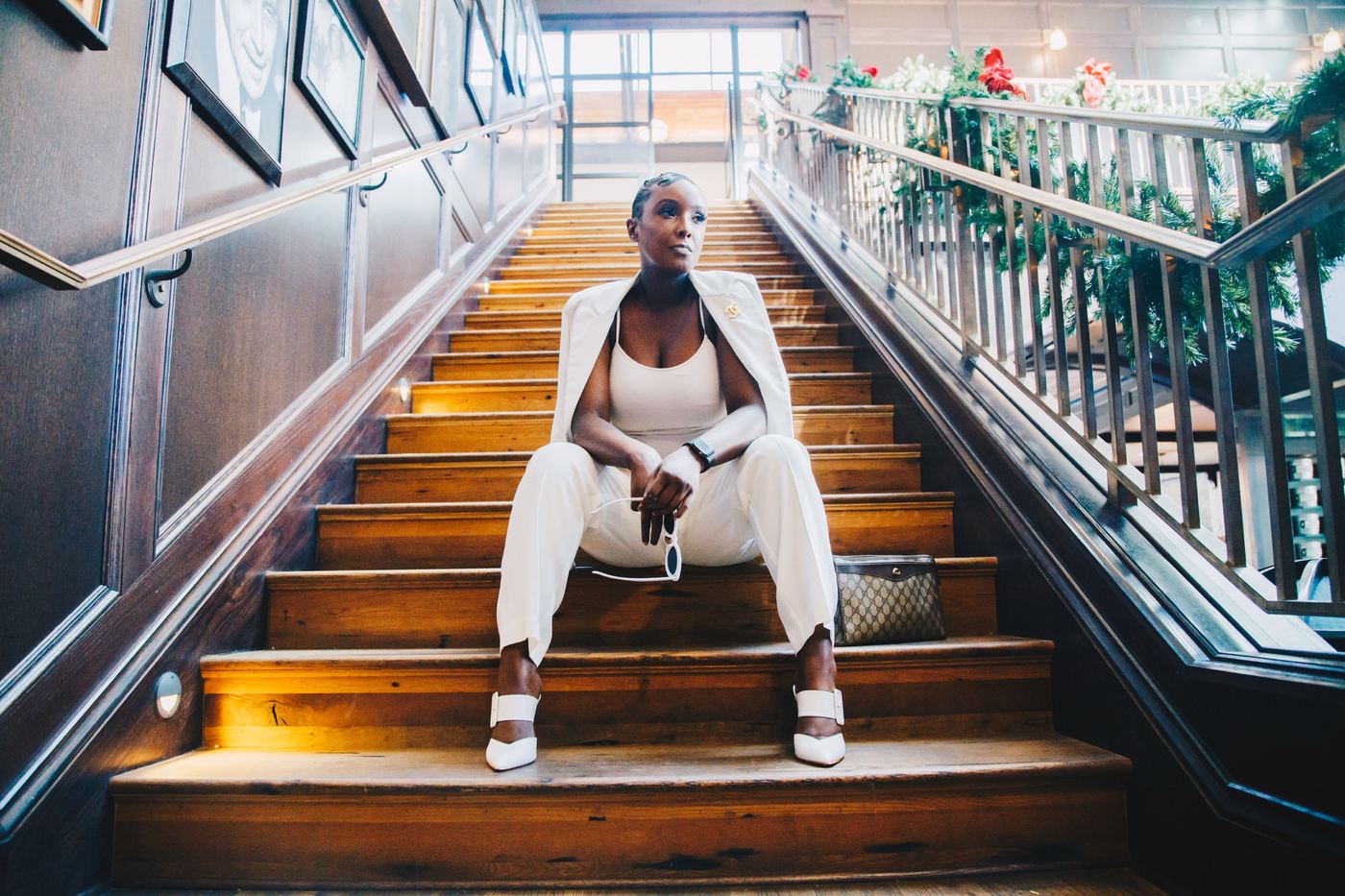 Founder in an all-white suit on a staircase