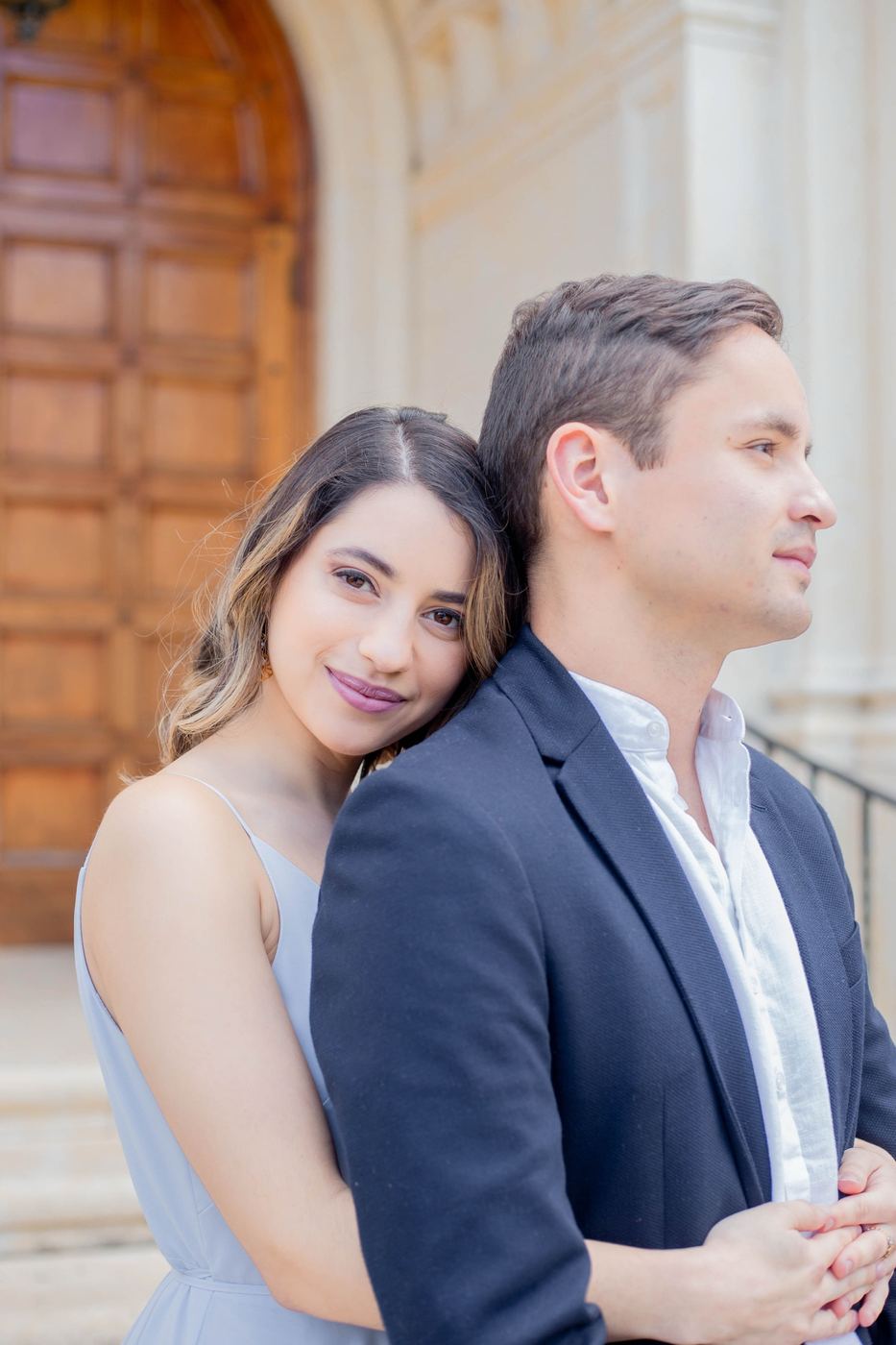 Engaged couple embracing by the chapel doors