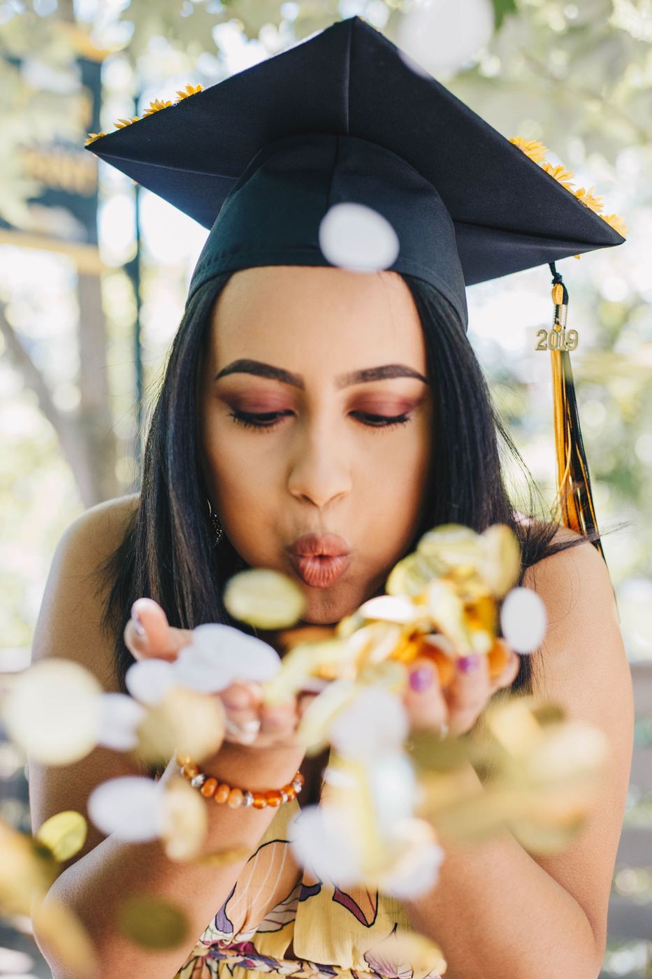 Graduate blowing confetti