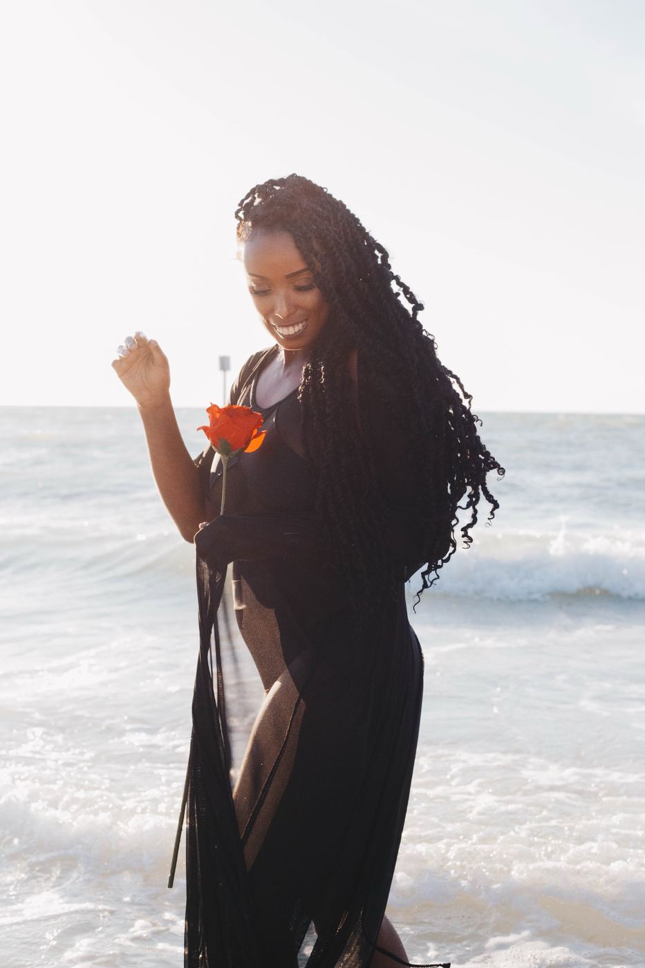 Smiling beach portrait with a rose