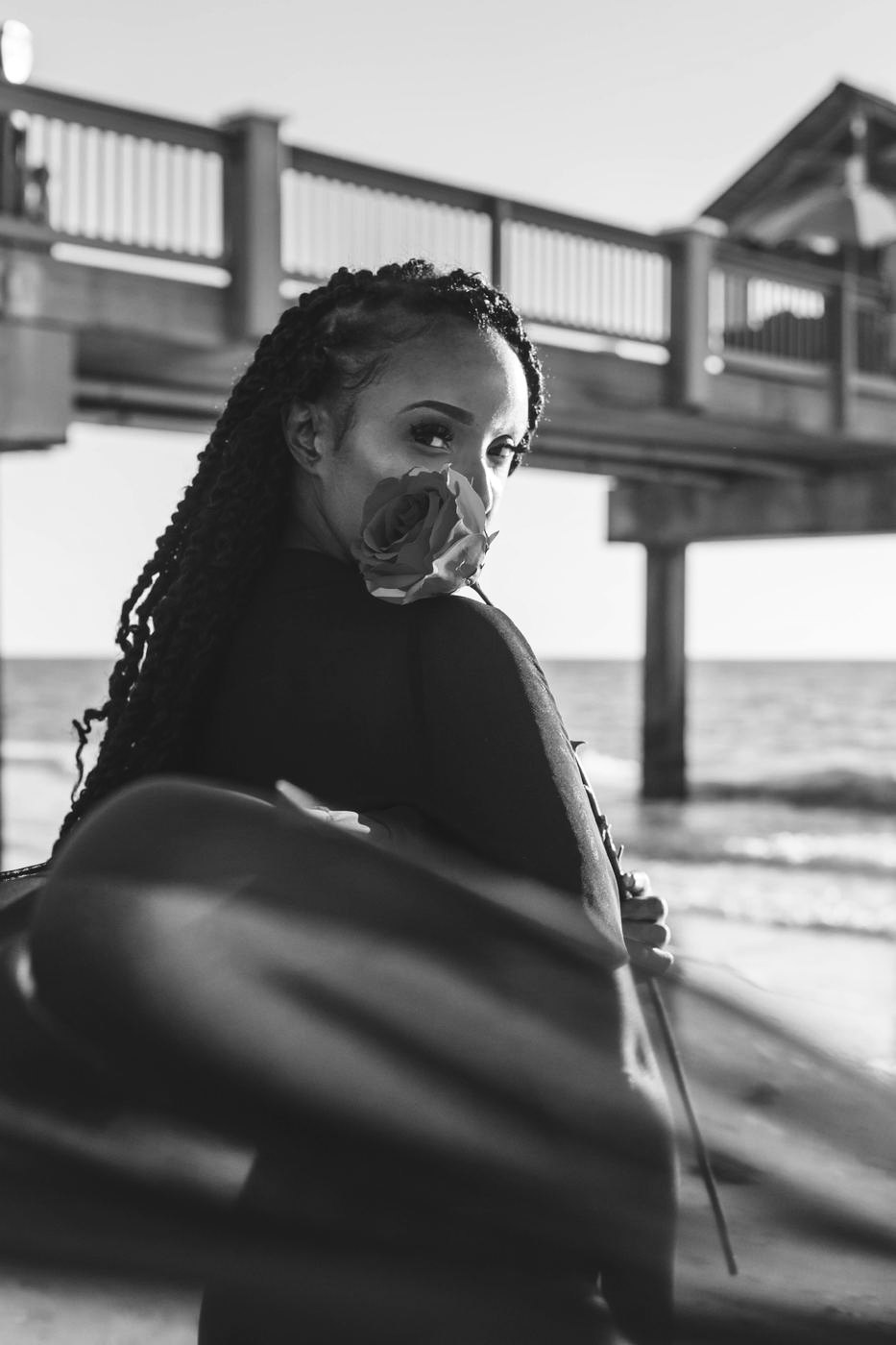Portrait by the pier holding a rose