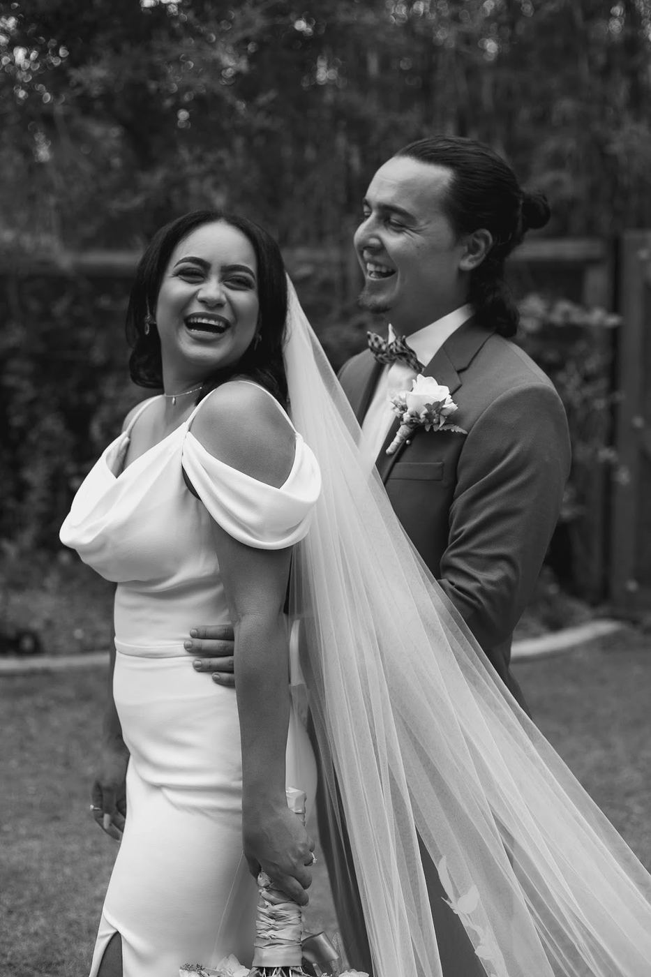 Bride and groom laughing in the garden