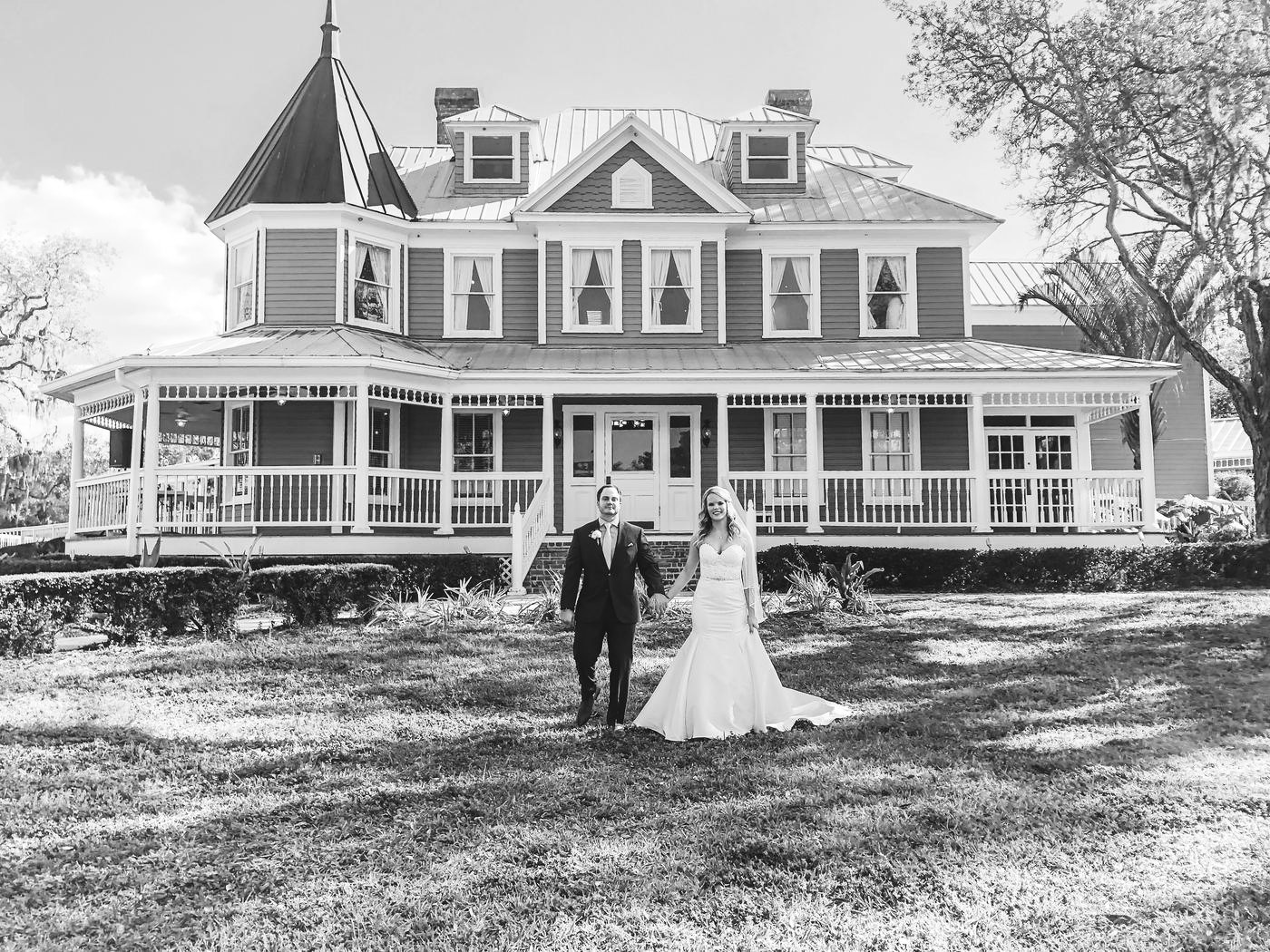 Newlyweds in front of a Victorian house
